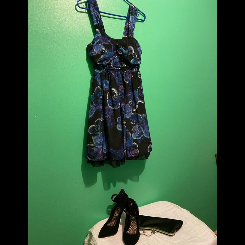 Black cocktail dress with blue floral pattern.